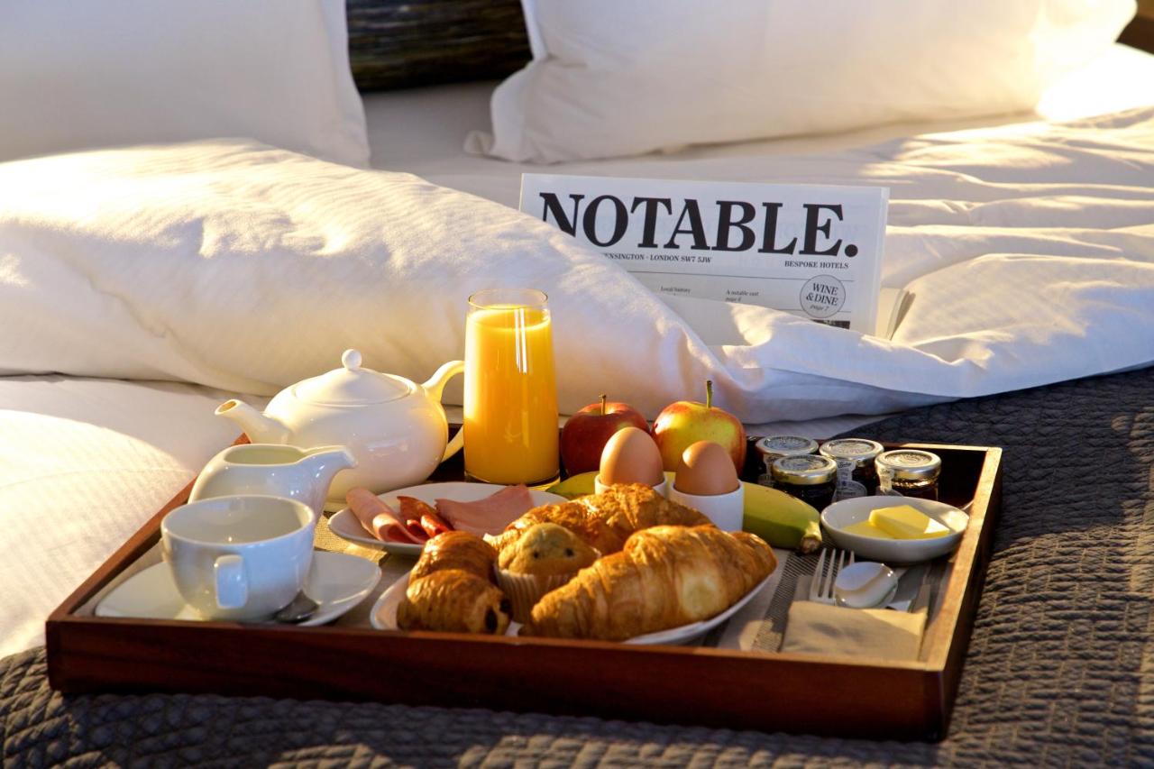 a tray of breakfast food on a bed at 54 Queen's Gate Hotel in London