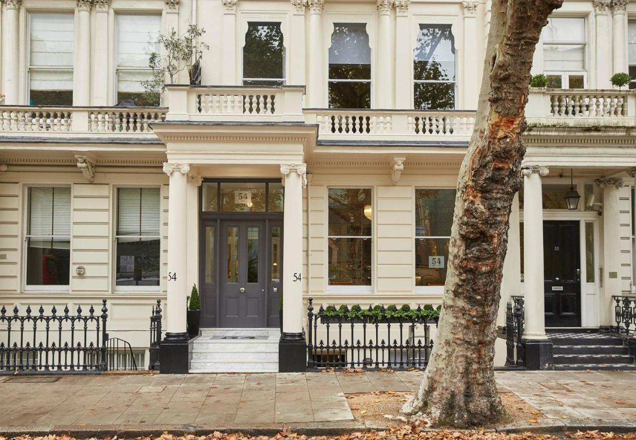 a white house with a tree in front of it at 54 Queen's Gate Hotel in London